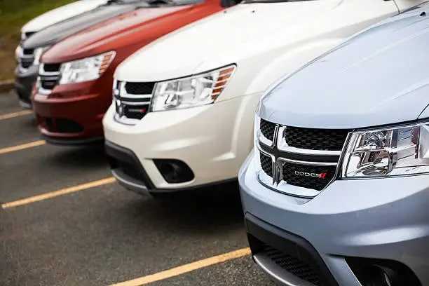 Dartmouth, Nova Scotia, Canada - October 28, 2012: Various colors of Dodge Journey vehicles in a row at a car dealership.  Vehicles sit in parking spaces and are separated by solid line.