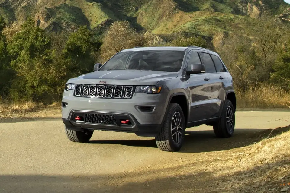 2021 Gray Jeep Grand Cherokee Trailhawk SUV driving on dirt mountain road