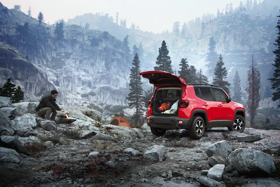 2021 Red Jeep Renegade SUV with open trunk parked on rocky mountain campsite