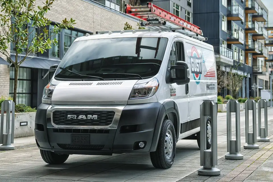 2021 White Ram ProMaster cargo van with roof ladder rack parked on city street