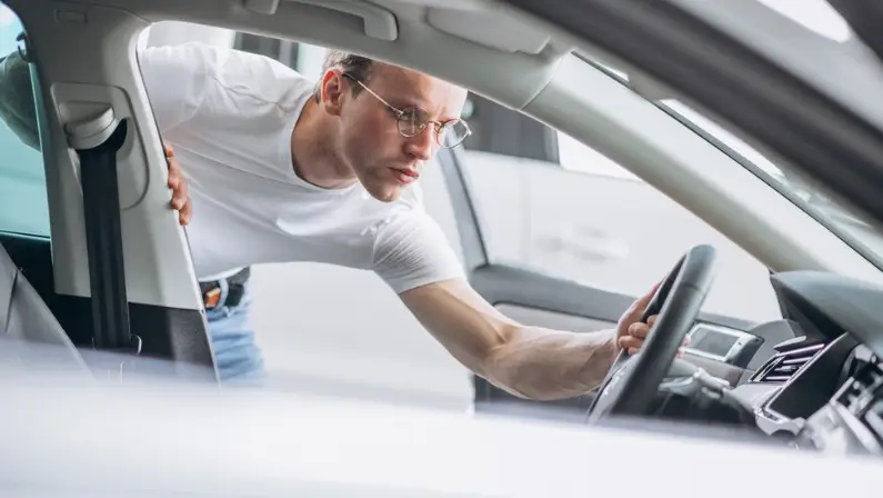 a-man-checking-the-car's-interior