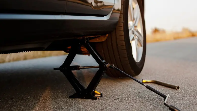 a-man-using-a-jack-to-lift-his-car