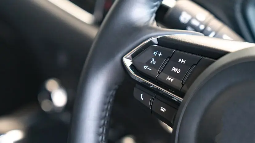 Close-up of steering wheel-mounted audio, phone, and trip info control buttons