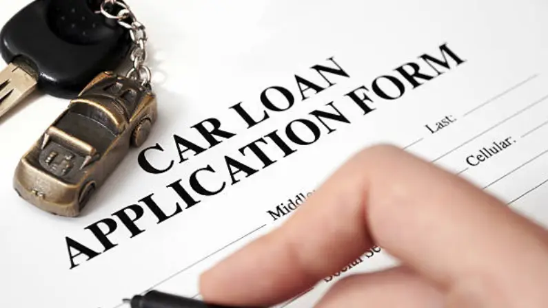 a-person-signing-a-car-loan-application-form