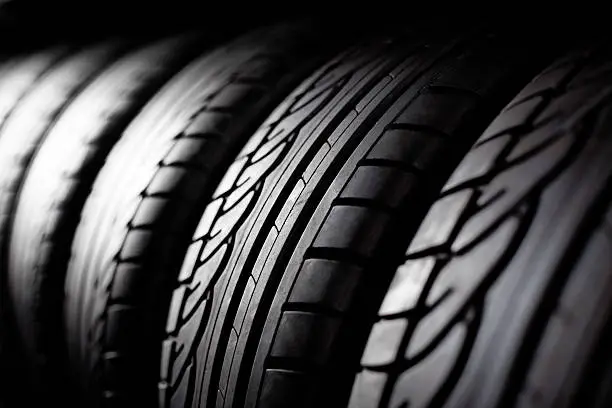 Close-up of stacked new car tires showing detailed tread pattern and sidewall texture