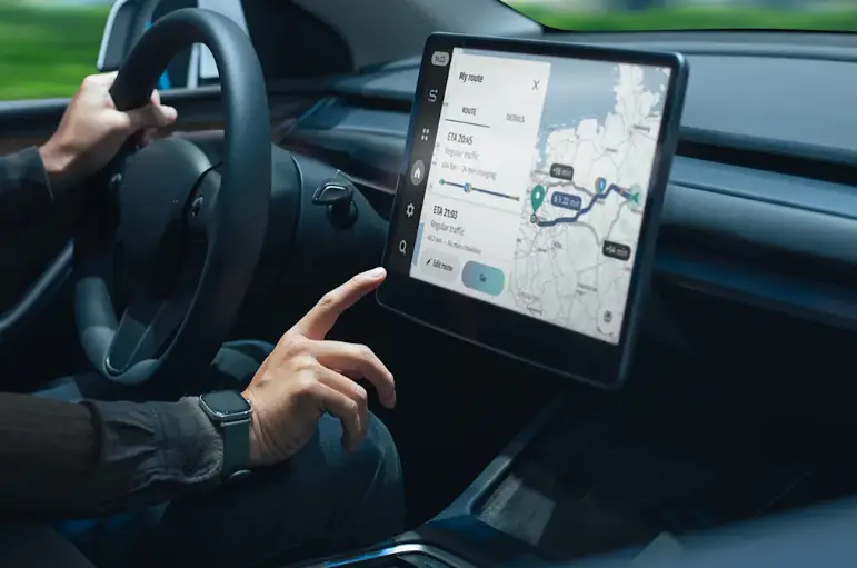Driver using touchscreen navigation map display while holding steering wheel in car