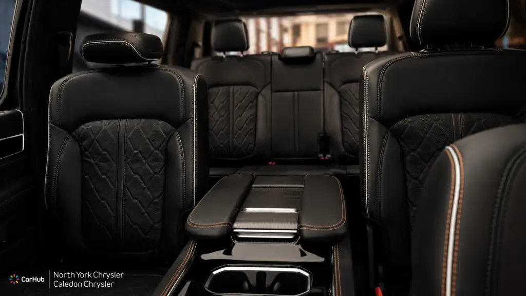 Premium black leather second-row captain's chairs and rear center console in a three-row Jeep Grand Wagoneer luxury SUV.